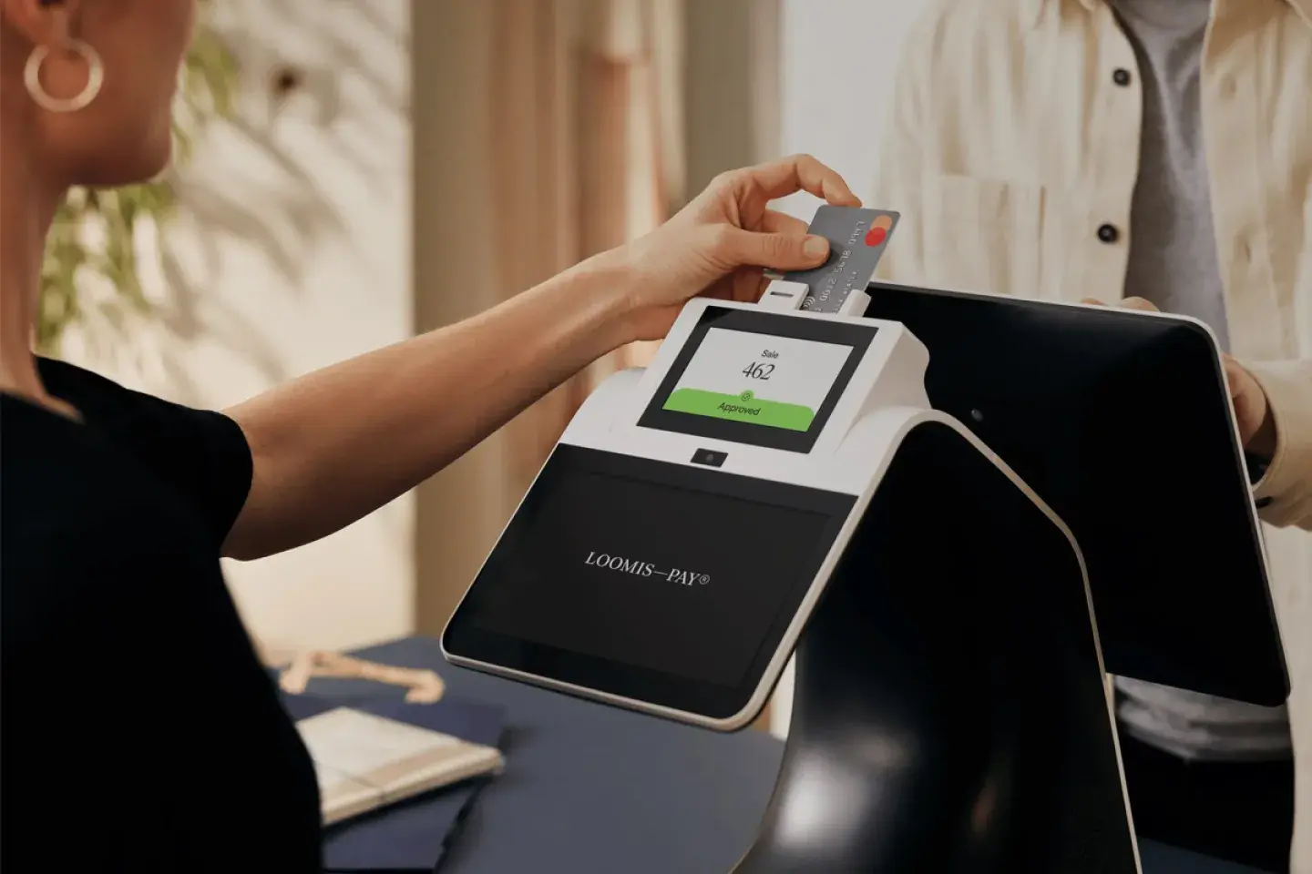 women using credit card on touchscreen payment device